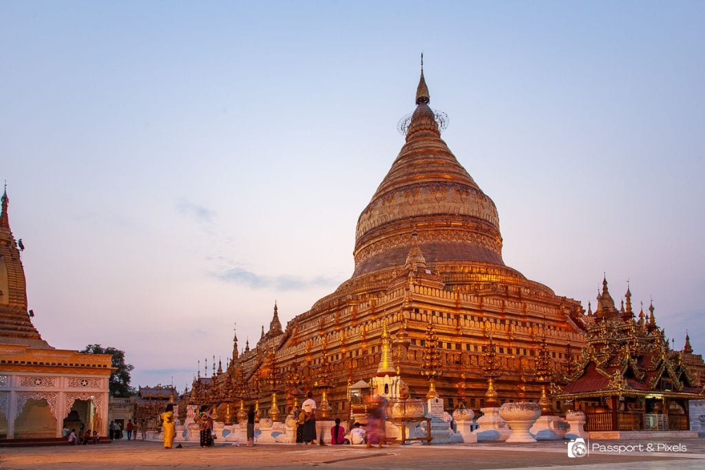 Is Bagan a Spiritual Place? Discover Why Should You Visit Bagan Myanmar in 2026! Sunset view of the magnificent Shwezigon Pagoda in Bagan, Myanmar, showcasing the golden glow on its intricate architecture, with visitors walking around and exploring the area.