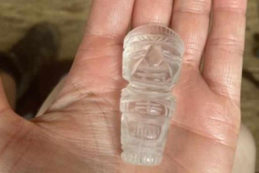 How to Get to the Lost City Colombia? My Personal Experience in 2026! A hand holding a small, clear, intricately carved crystal figurine, likely a representation of an indigenous artifact.