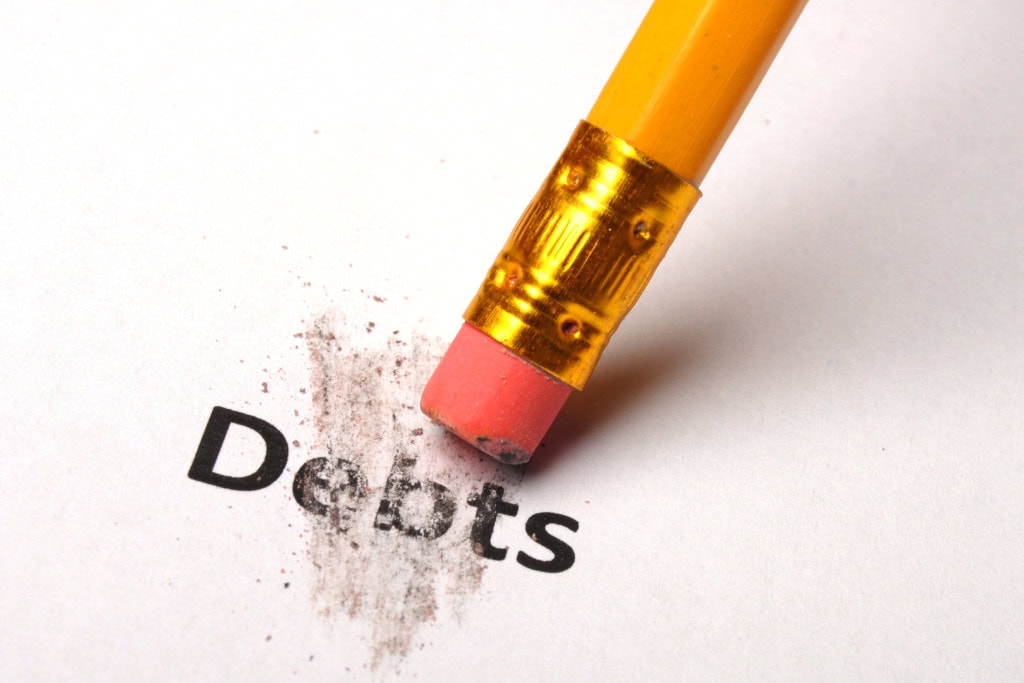 Cleansing Your House from Negative Energy: Everything You Need to Know! This image shows a close-up of a pencil eraser in the process of erasing the word "Debts" from a sheet of paper. The smudges left behind highlight the action of clearing or reducing debt, symbolizing financial freedom or relief from financial burdens. The composition conveys a positive message of overcoming financial challenges.