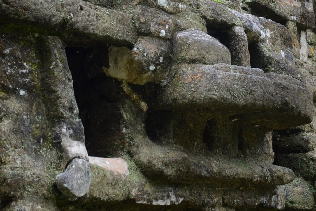 Huancabamba in Peru: Embark On A Spiritual Journey A close-up of an ancient stone structure, showcasing its rough texture and weathered surfaces with moss and lichen adding a natural touch. The intricate carvings and crevices suggest historical significance, likely linked to an archaeological site.