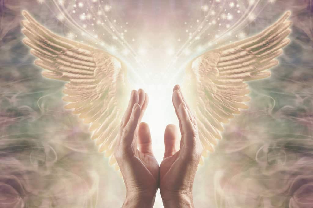 Angel Number 1 Spiritual Message You Must Not Ignore Two hands reaching toward golden angel wings surrounded by sparkling light, symbolizing the support and guidance linked with Angel Number 1.