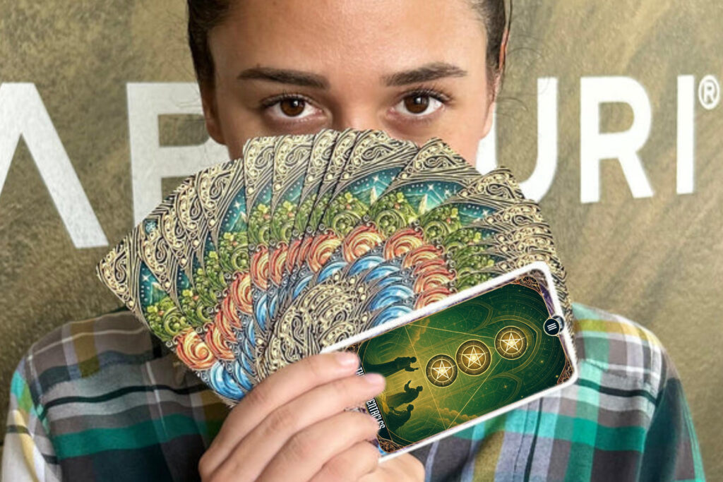 Person holding a fan of tarot cards featuring the Three of Pentacles from the Suit of Pentacles tarot card meaning, representing teamwork, growth, and creation.