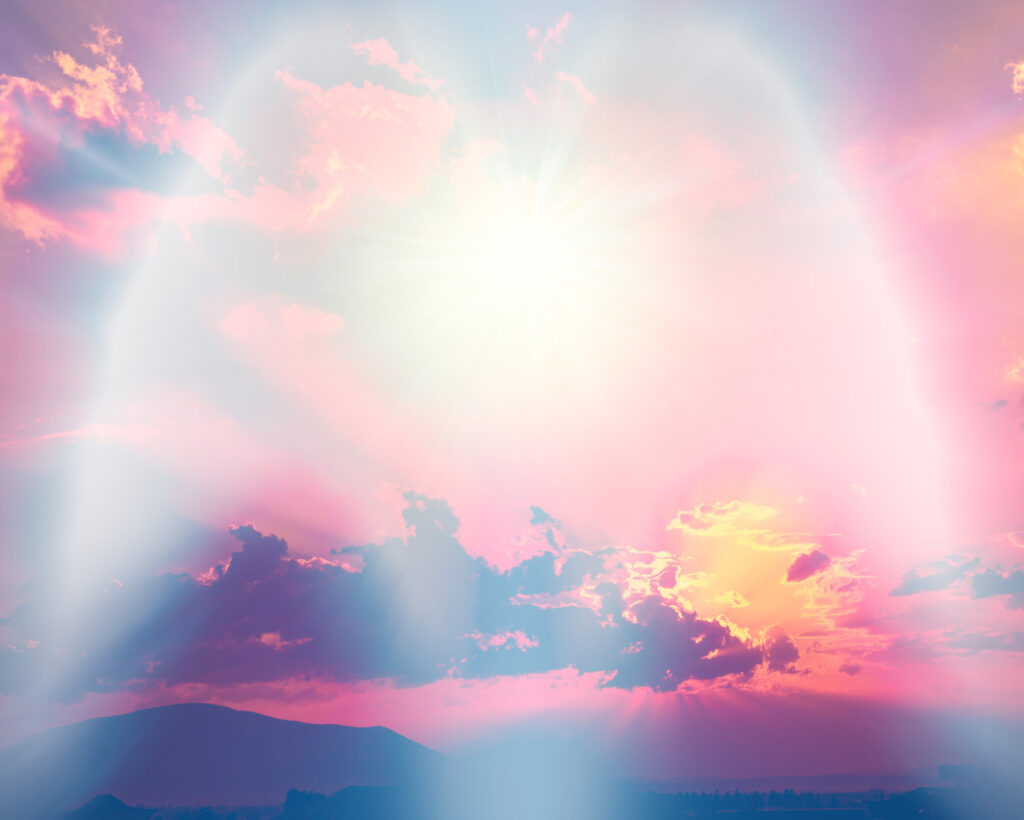 Angel Number Cheat Sheet: Everything You Need to Know About Angel Numbers Heavenly light shining through pink and purple clouds above mountains, creating an ethereal scene associated with divine guidance and all angel numbers.
