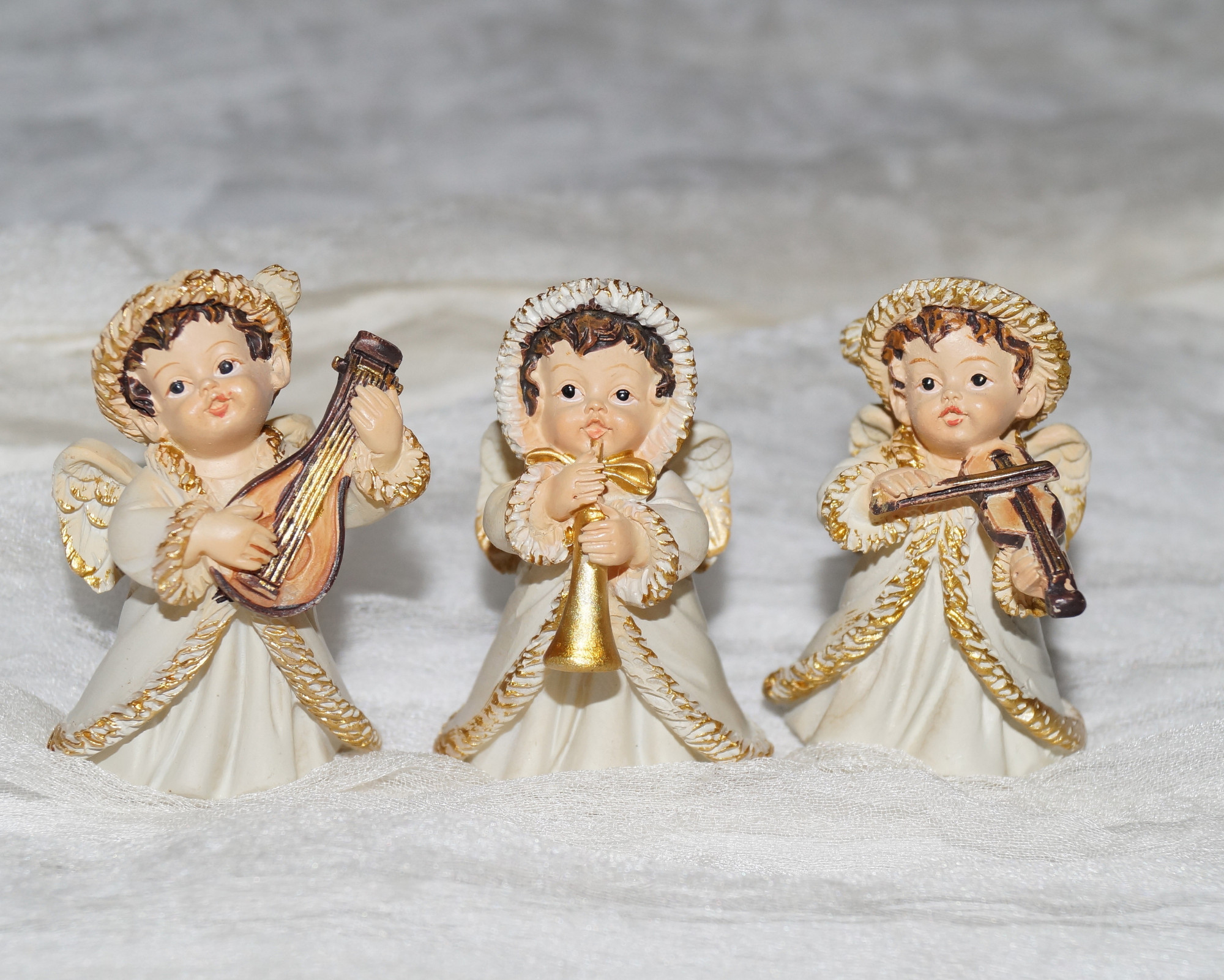 All Angel Numbers: The Guide to Angel Numbers and What They Mean Close-up of three small angel figurines playing musical instruments, symbolizing divine guidance and support often connected to angel numbers and what they mean.