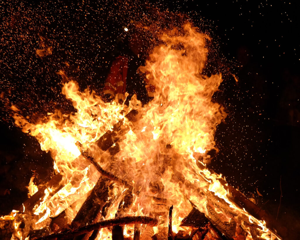 A powerful Samhain bonfire blazing in the dark, capturing what to do for Samhain when performing fire rituals for release and protection.