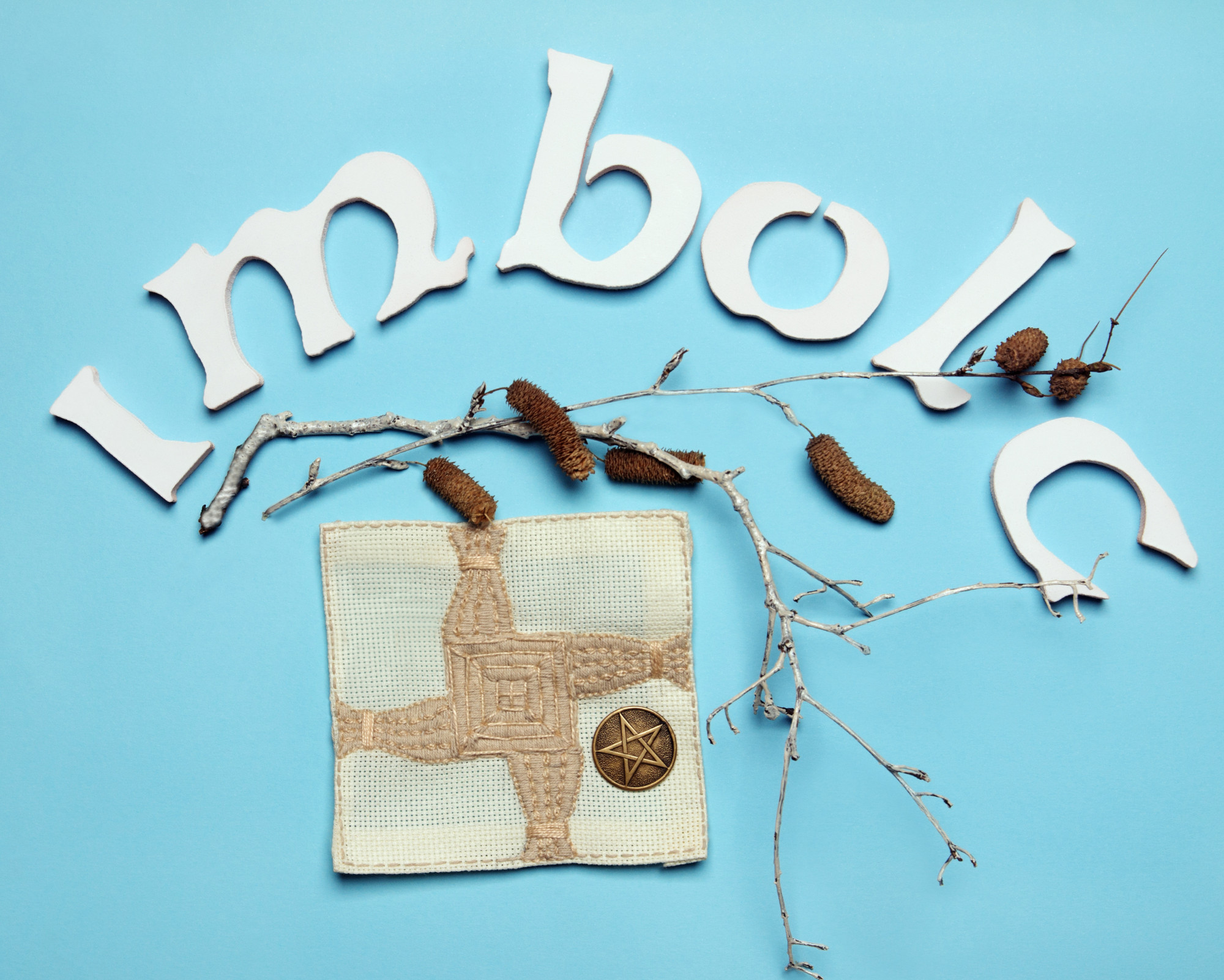 Imbolc celebration symbol featuring a handmade Brigid cross and natural materials representing protection and new beginnings