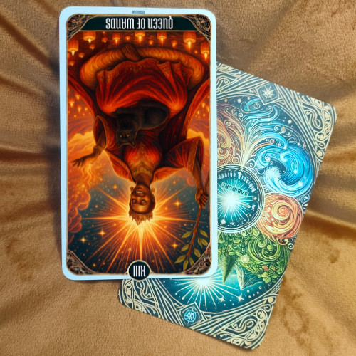 Queen of Wands Tarot Meaning - Minor Arcana Tarot Card Meanings Reversed Queen of Wands tarot card meaning illustrated with the card upside down beside a colorful tarot deck, symbolizing blocked confidence and inward fire.