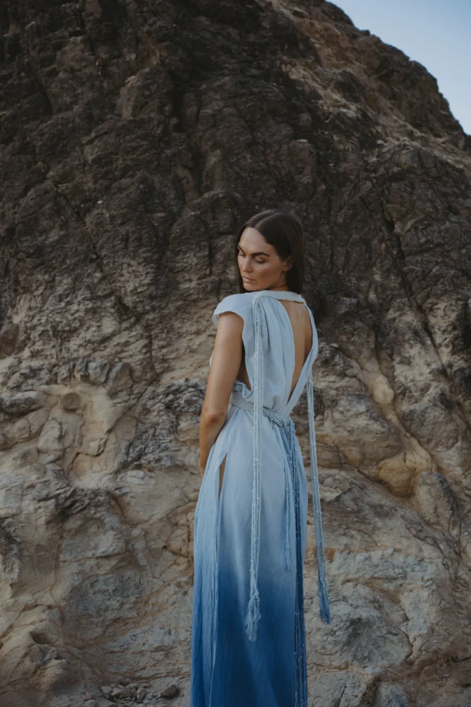 When the Mountains Called Me Home: How Peru Re-Mapped My Inner Compass Author of the Peru trip, Lyndsey Logan, in a blue dress on a rocky place.