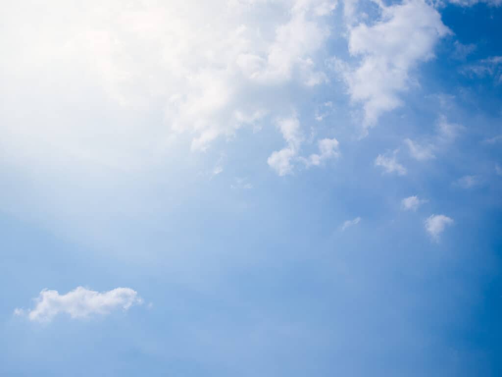 Sky with clouds and sunlight breaking through, symbolizing spiritual awakening and enlightenment.