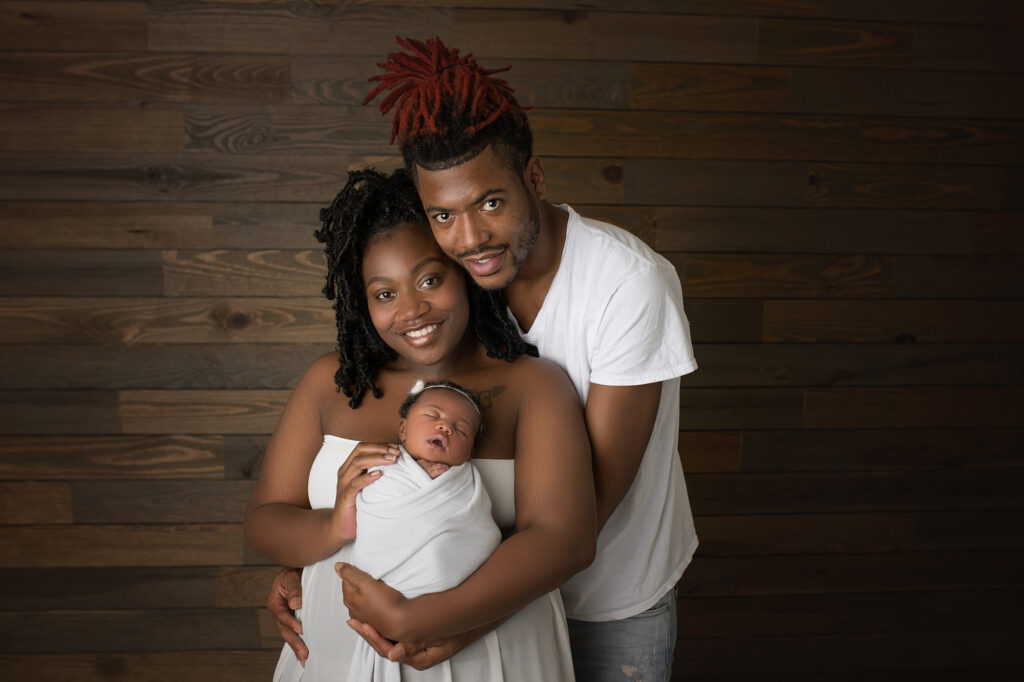 newborn baby girl being cuddled by mom and dad