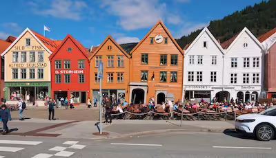 Kleurrijke, scheve gevels van Bryggen met drukke terrassen in Bergen, Noorwegen