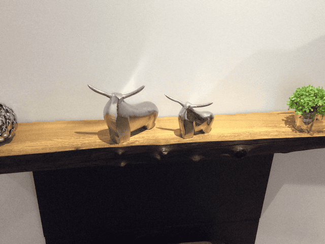 A waney edge mantel with decorations on top - sent by a customer