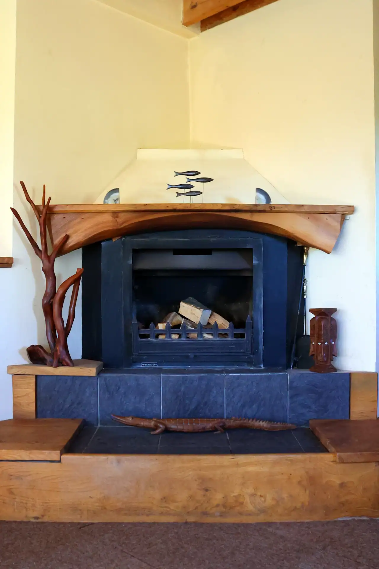 Natural edge elm mantel piece over an open fireplace
