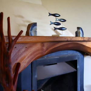 Fireplace with live, natural edge elm mantel piece, shaped in an arch over the fire