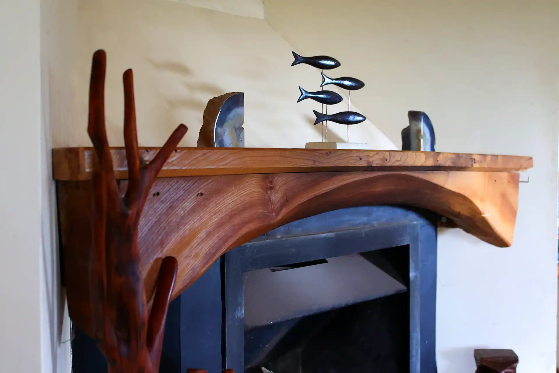Fireplace with live, natural edge elm mantel piece, shaped in an arch over the fire