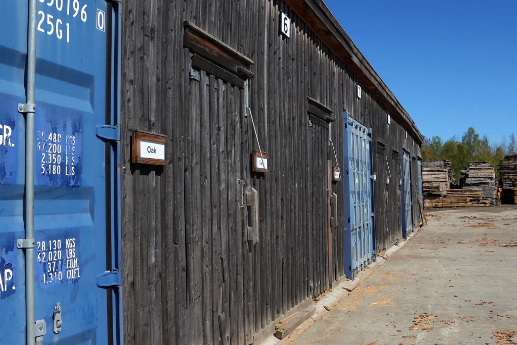 View of timber clad sheds at Scottish Wood sawmill, being used to store kiln dried rough sawn hardwoods