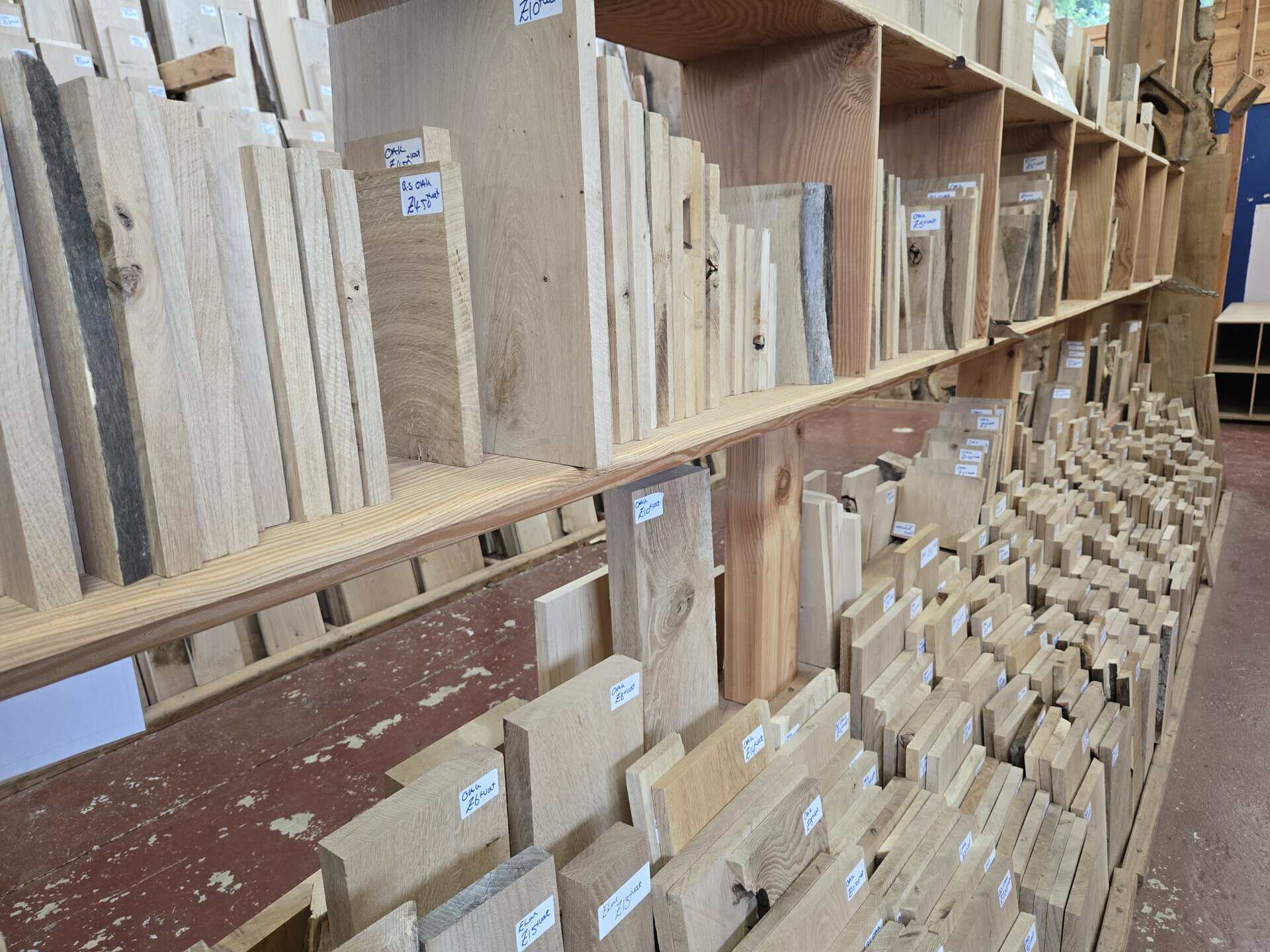 Assorted hardwood offcuts and blanks in various sizes on display shelves in a timber shop.