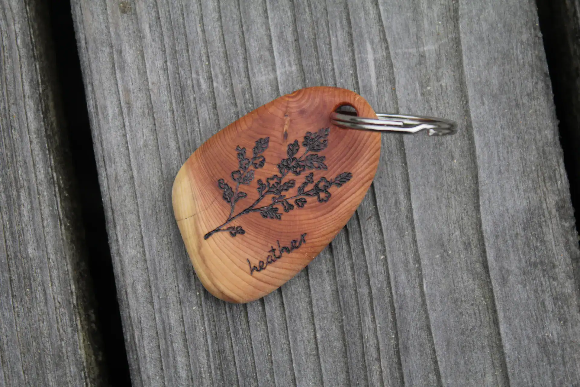 A keychain made of Scottish Yew with a pyrography of a heather plant