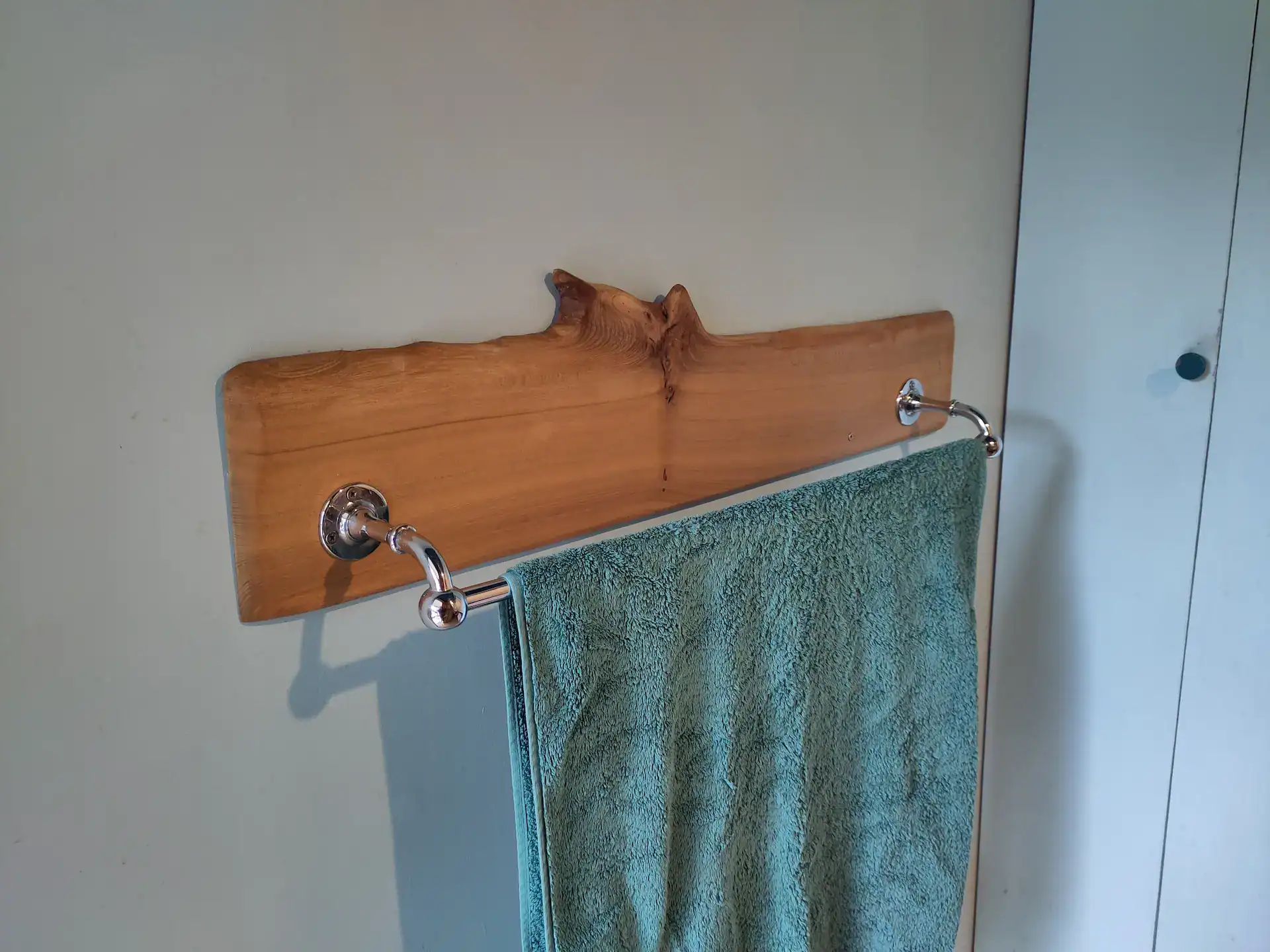 Natural, waney edge elm board used as a decorative mount for a towel rail