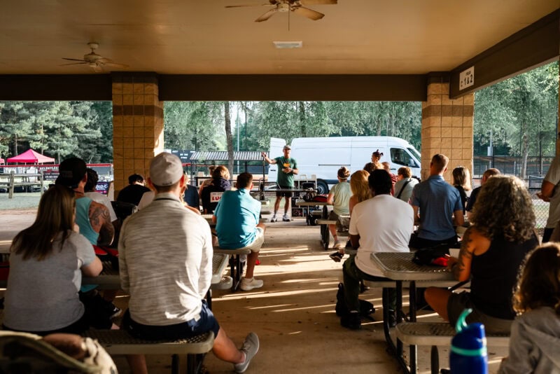 The Perfect EDC Camera - Nikon Zf Outdoor seminar with an engaged audience under a covered pavilion.