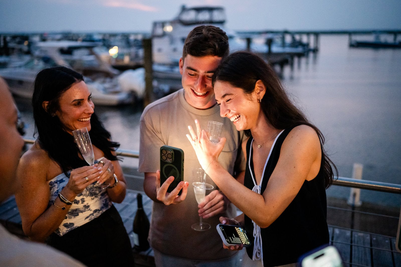 FAQ: The Ins and Outs of Proposal Photography Friends celebrating engagement at marina