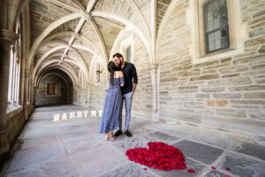 Romantic proposal in historic stone corridor.