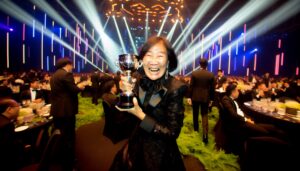 Woman celebrating with trophy at award ceremony