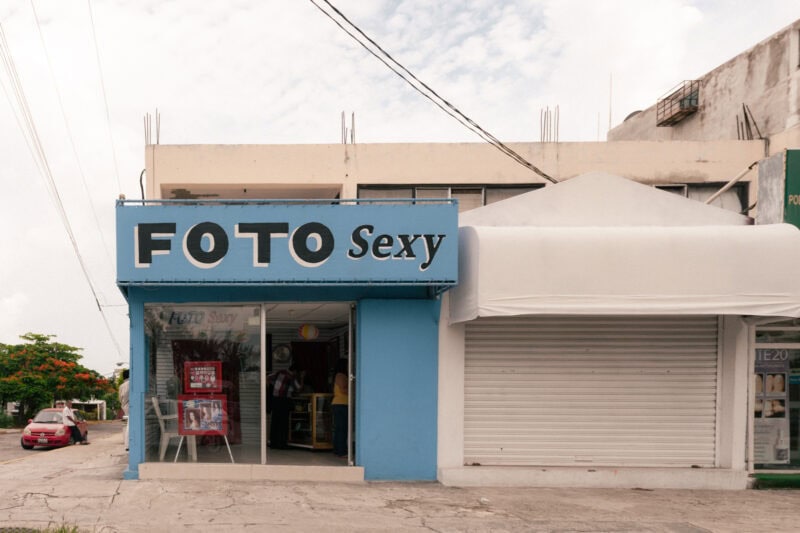 Photo shop with blue sign on street corner.