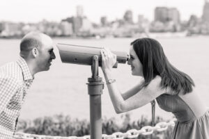 Couple enjoying city view through a telescope.
