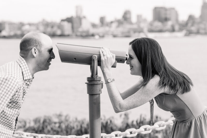 Couple enjoying city view through a telescope.