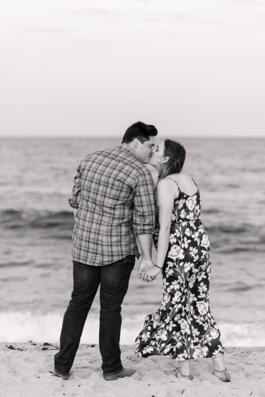 The Perfect Black & White Photo Editing Style Couple kissing on beach, holding hands.
