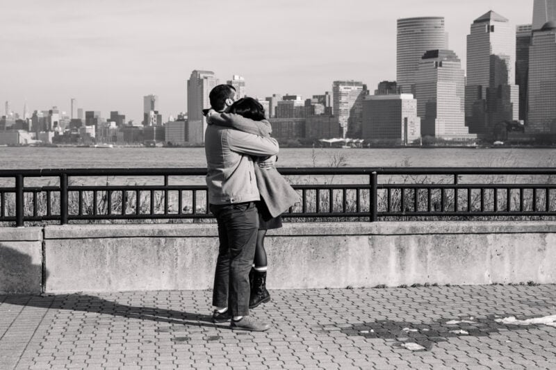 The Perfect Black & White Photo Editing Style Couple hugging by waterfront with city skyline.