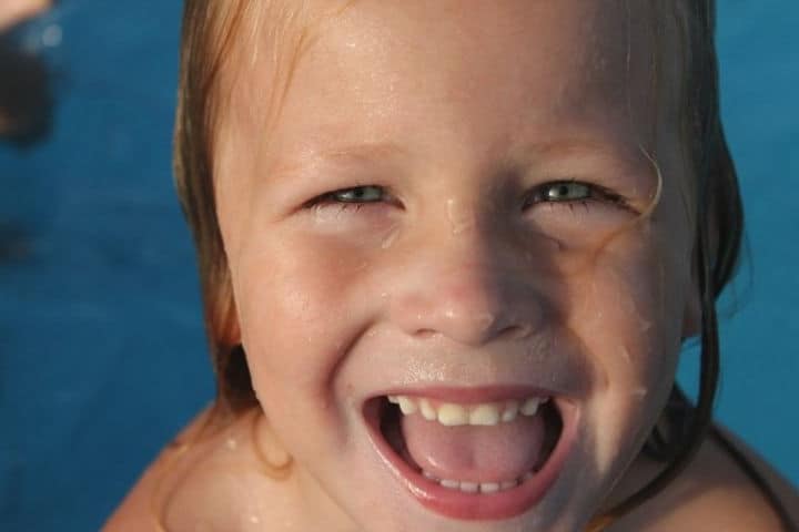 kid enjoying and smiling in pool