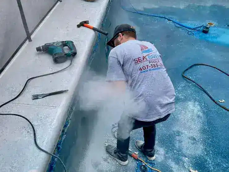 Sea Breeze worker using power tools to fix the pool shell.