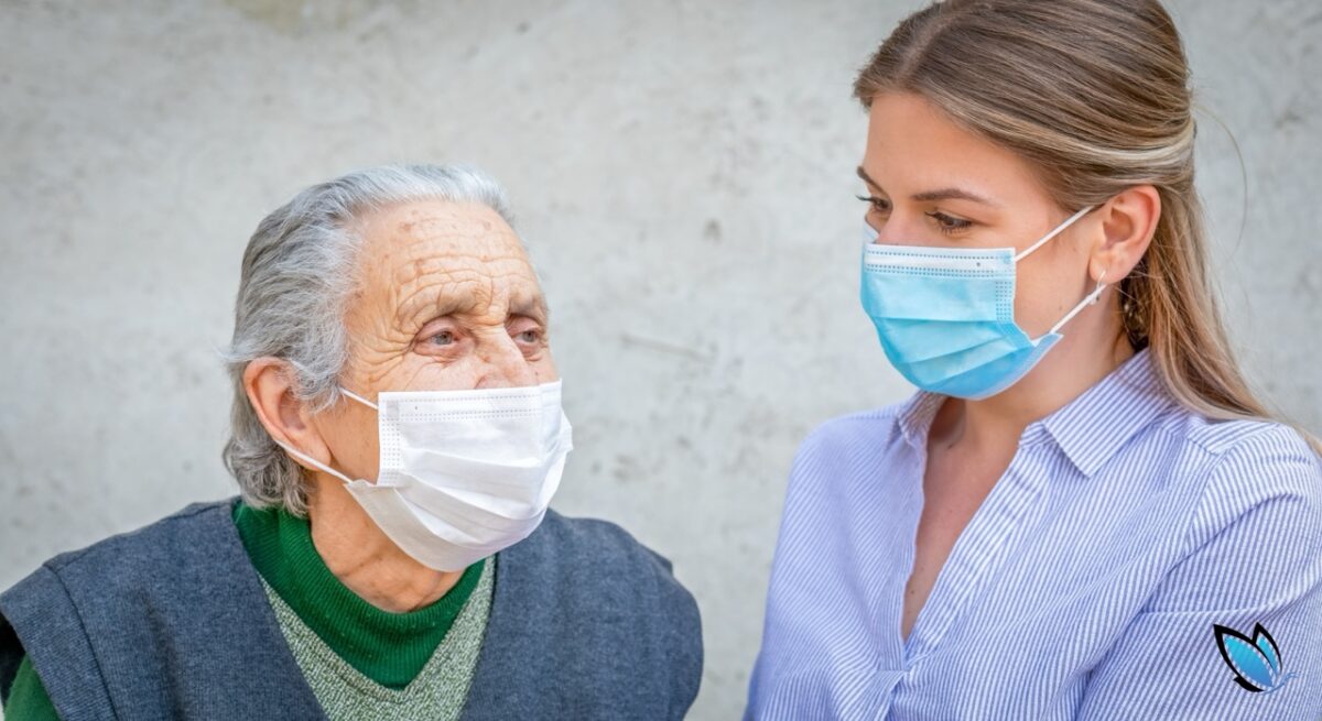 an elderly woman with her adult daughter wearing masks