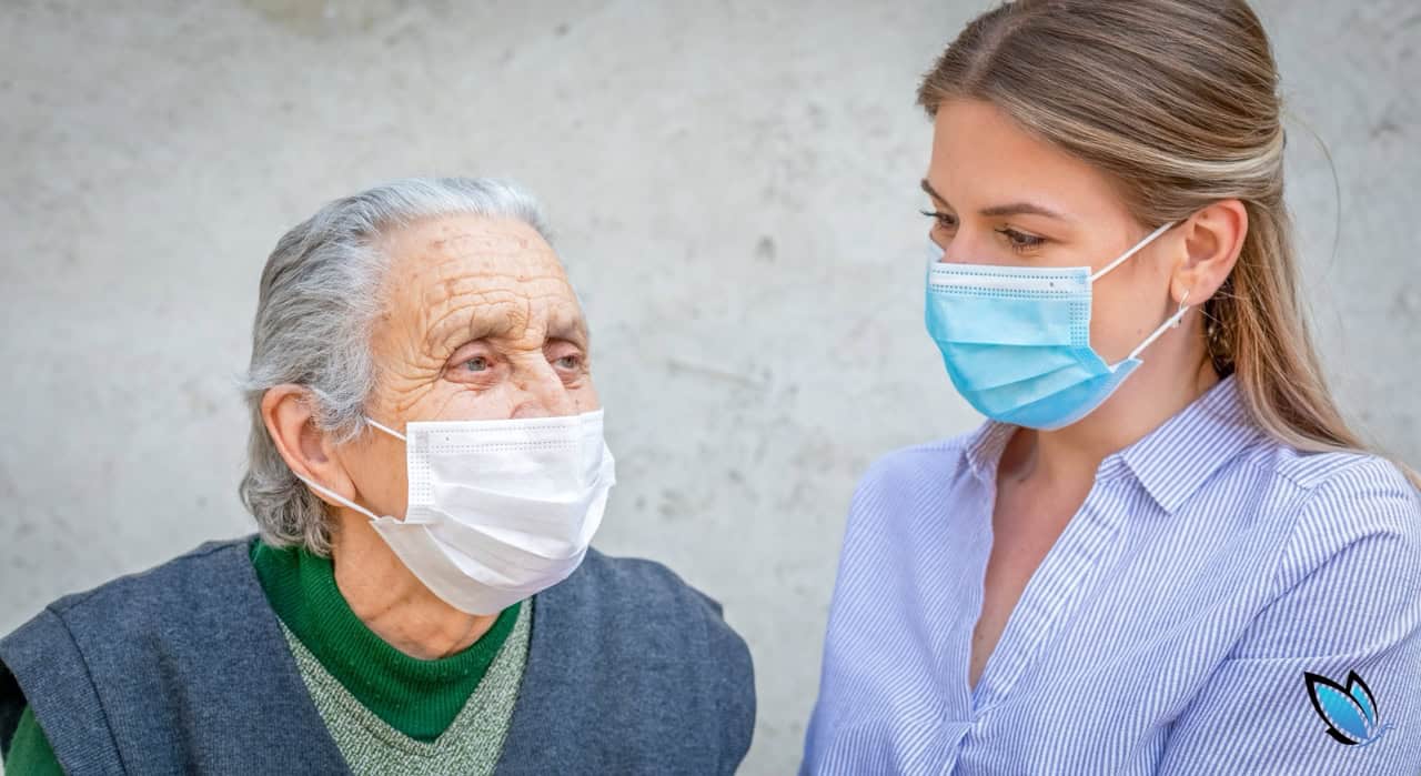 an elderly woman with her adult daughter wearing masks