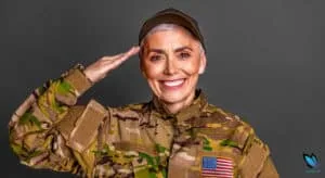 Senior veteran woman saluting and smiling for VA Aid and Attendance for Assisted Living