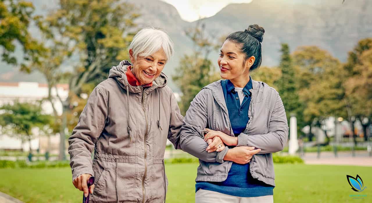 Caregiver helping Senior resident go for a walk outside the senior living community