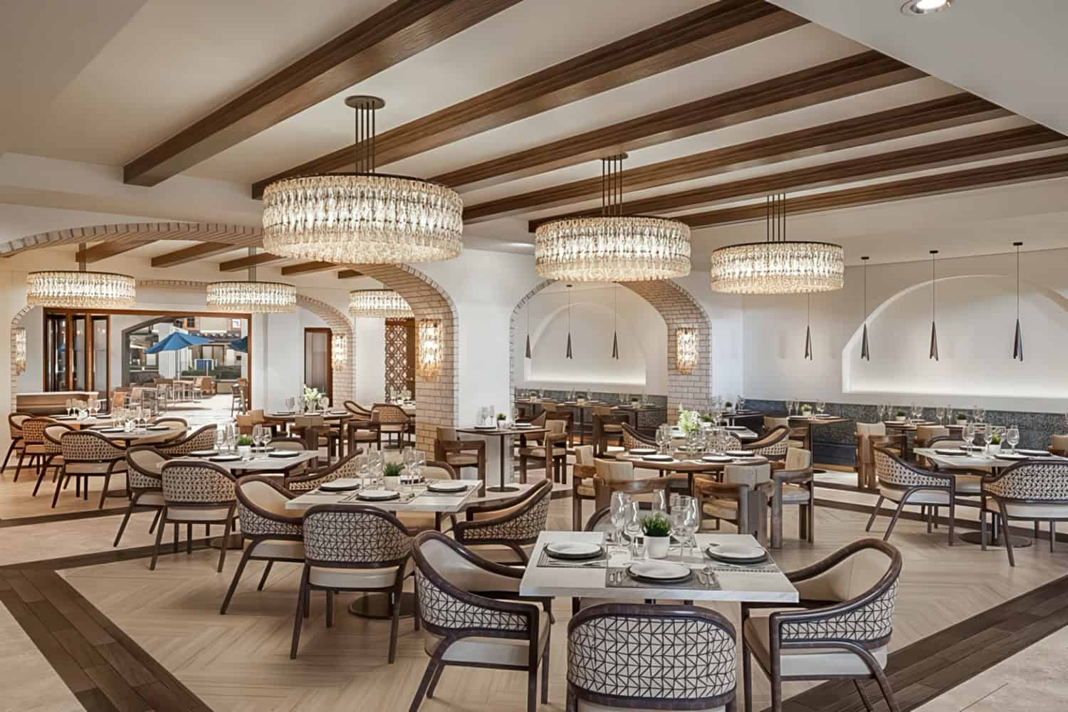 Beautiful dining area of Belmont Village with chandeliers and modern tables and furniture