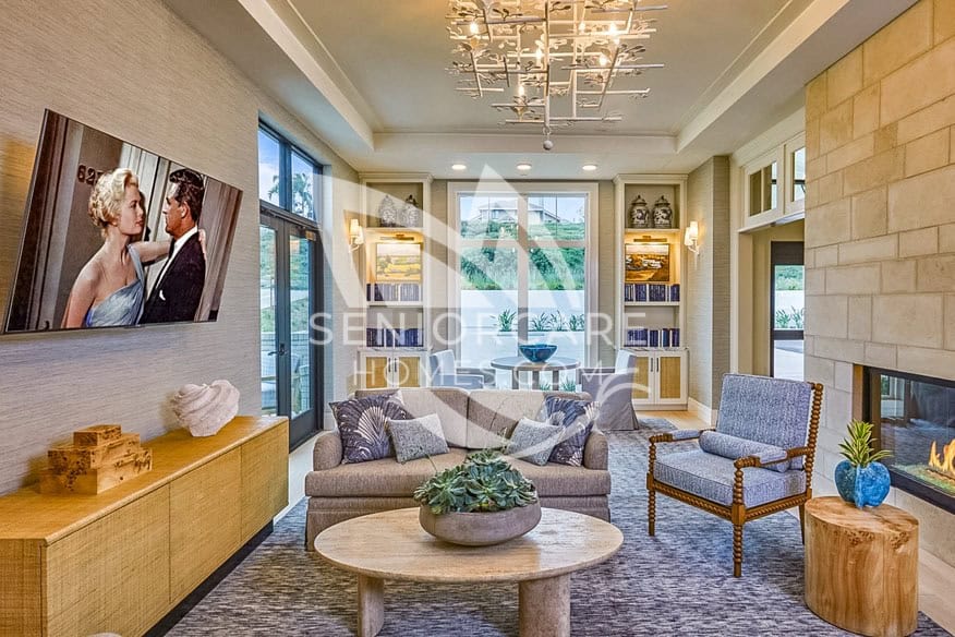 Beautiful lounge area with TV and chandelier at Seville Senior Living