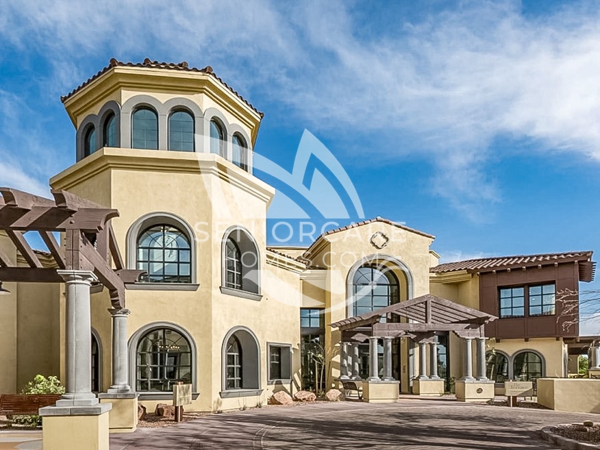 Exterior of Clearwater at Pinnacle Peak, a Mediterranean-style building with a round tower, arched windows, tile roofs, and a pergola entryway.