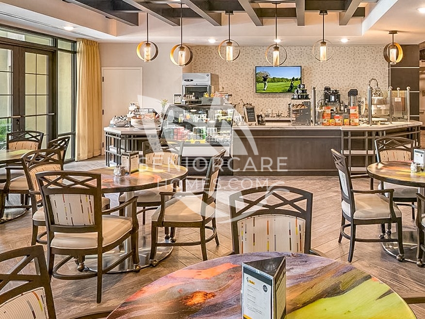Café at Clearwater at Pinnacle Peak with round tables, upholstered chairs, a pastry case, a coffee bar, and globe pendant lights.