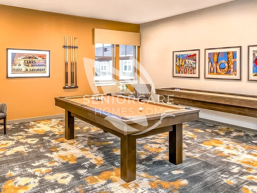 Game room at Clearwater at Rancharrah with a pool table, a shuffleboard table, a wall-mounted cue rack, and colorful vintage sign artwork.