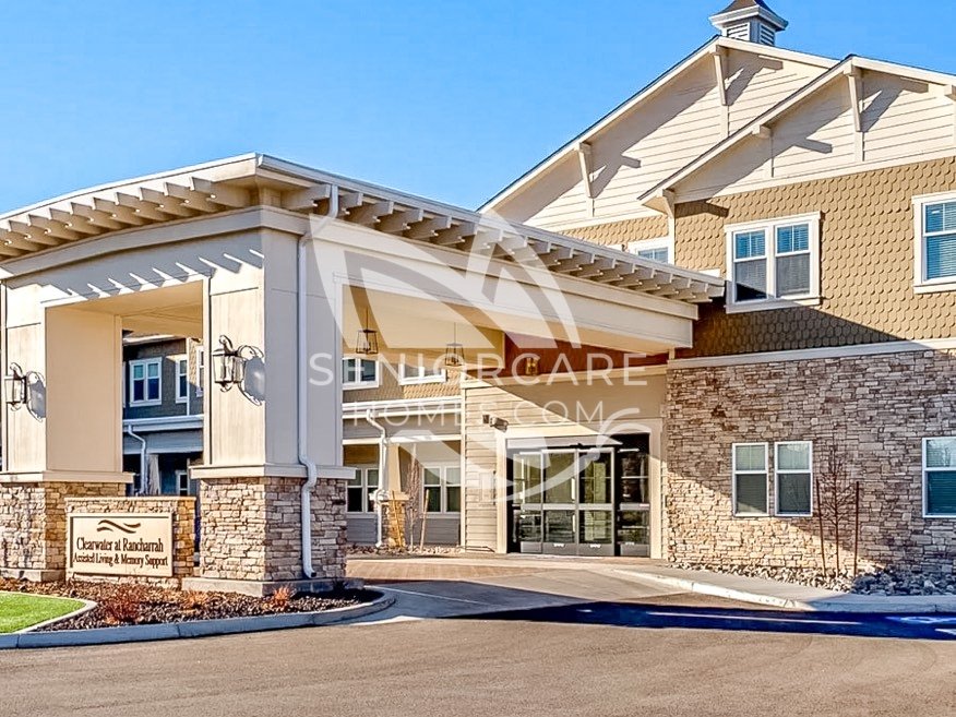 Main entrance of Clearwater at Rancharrah with a covered drop-off area, stacked stone columns, and a monument sign reading Clearwater at Rancharrah Assisted Living & Memory Support.