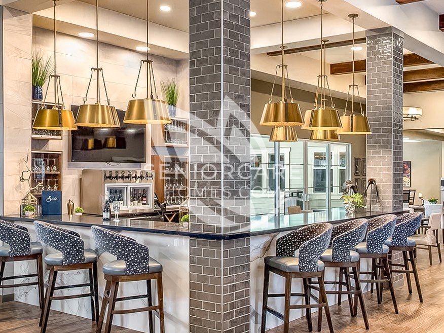 Bar at Clearwater at Rancharrah with patterned counter stools, brass pendant lights, gray brick columns, and a wine tap station.