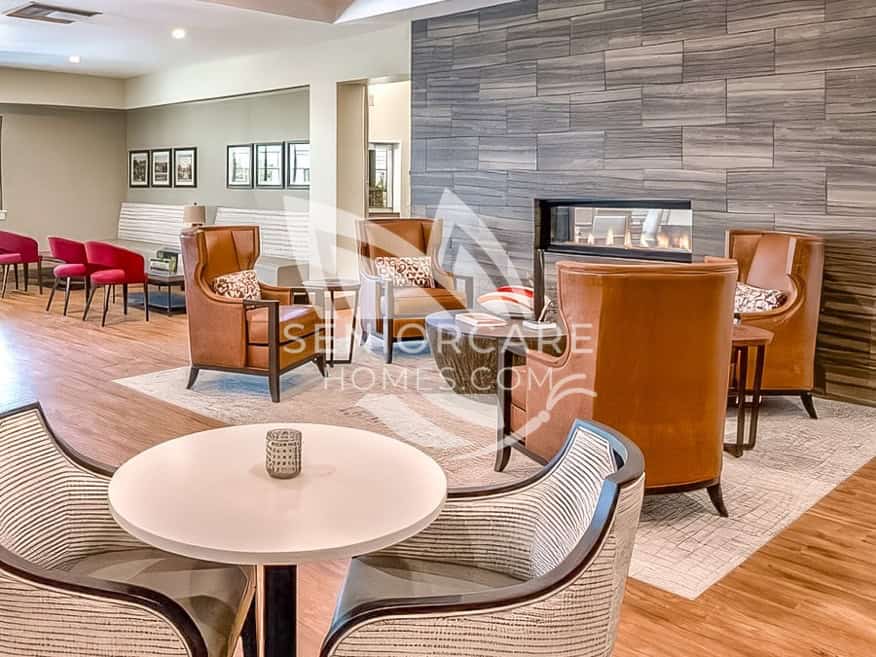 Lounge at Clearwater at Sonoma Hills with caramel leather wingback chairs around a double-sided fireplace set in a gray stone wall.