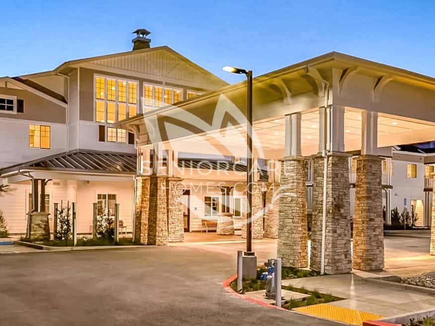 Main entrance of Clearwater at Sonoma Hills at dusk, with a covered drop-off area supported by stacked stone columns.