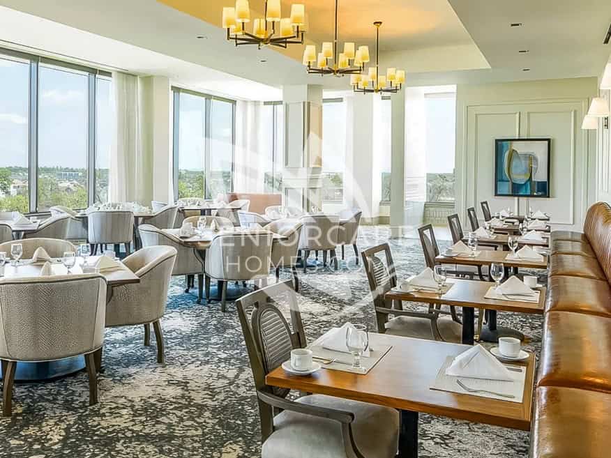 Formal dining room at Clearwater at The Heights with white tablecloths, upholstered chairs, leather banquette seating, and floor-to-ceiling windows.
