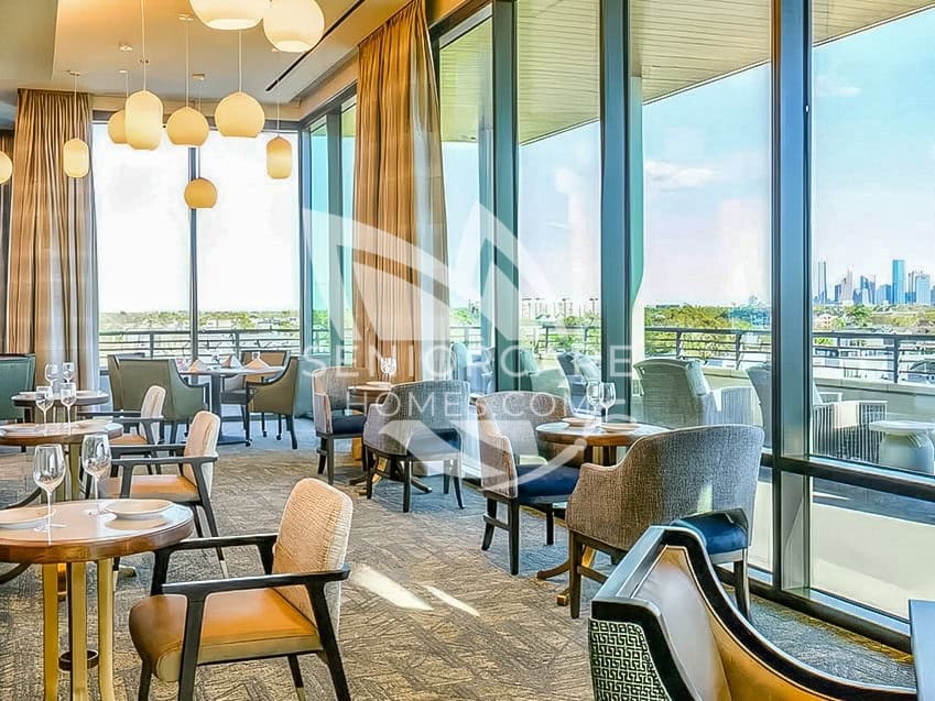Upper-floor dining room at Clearwater at The Heights with floor-to-ceiling windows, an outdoor terrace, and views of the city skyline.