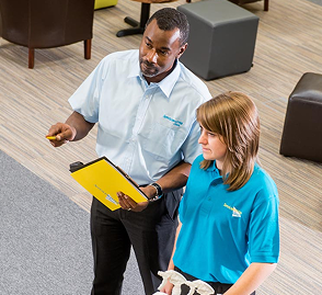 Cleaning professionals discussing service details with a client.